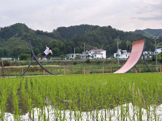 滑手在村中体验滑板道具。新华社记者 王沁鸥 摄