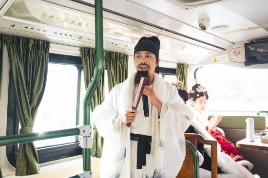 身着古装的“伴游”在“长安寻梦”主题观光车上为游客讲解。(受访者供图)