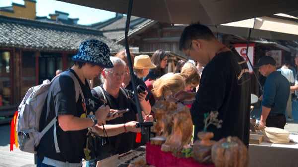 “五一”期间,游客正在乌镇“水乡码头”挑选购买文创产品。受访者供图